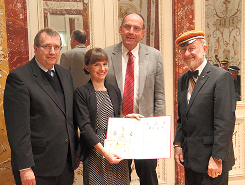 Universitätspräsident Alfred Forchel mit Preisträgerin Ann-Christin Schuster, ihrem Doktorvater Markus Riederer und dem Leiter der Festveranstaltung, Bernhard Edler von Lapp. (Foto: Albrecht Fehlig)